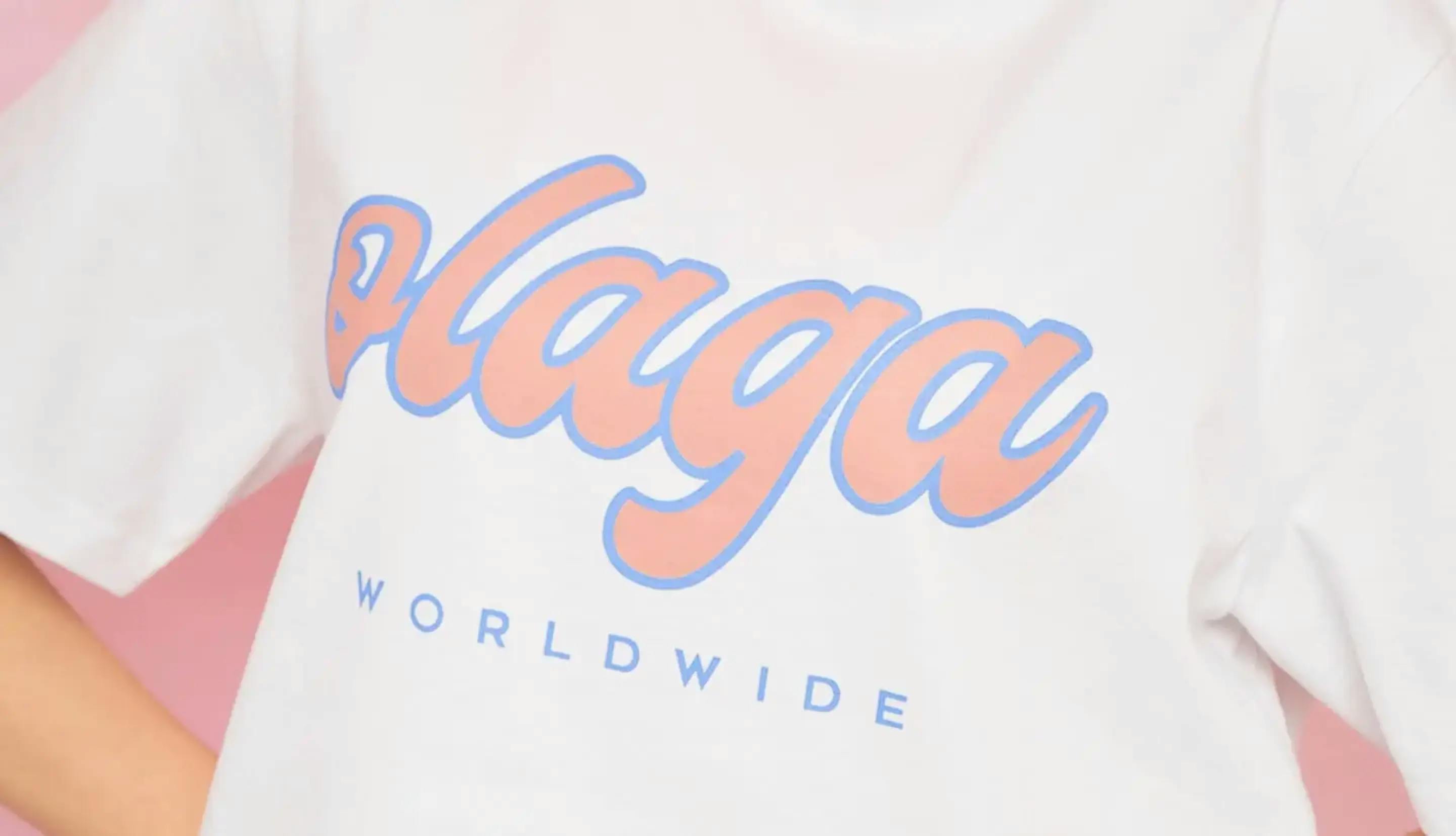 A person wearing a white Olaga Studios T-shirt